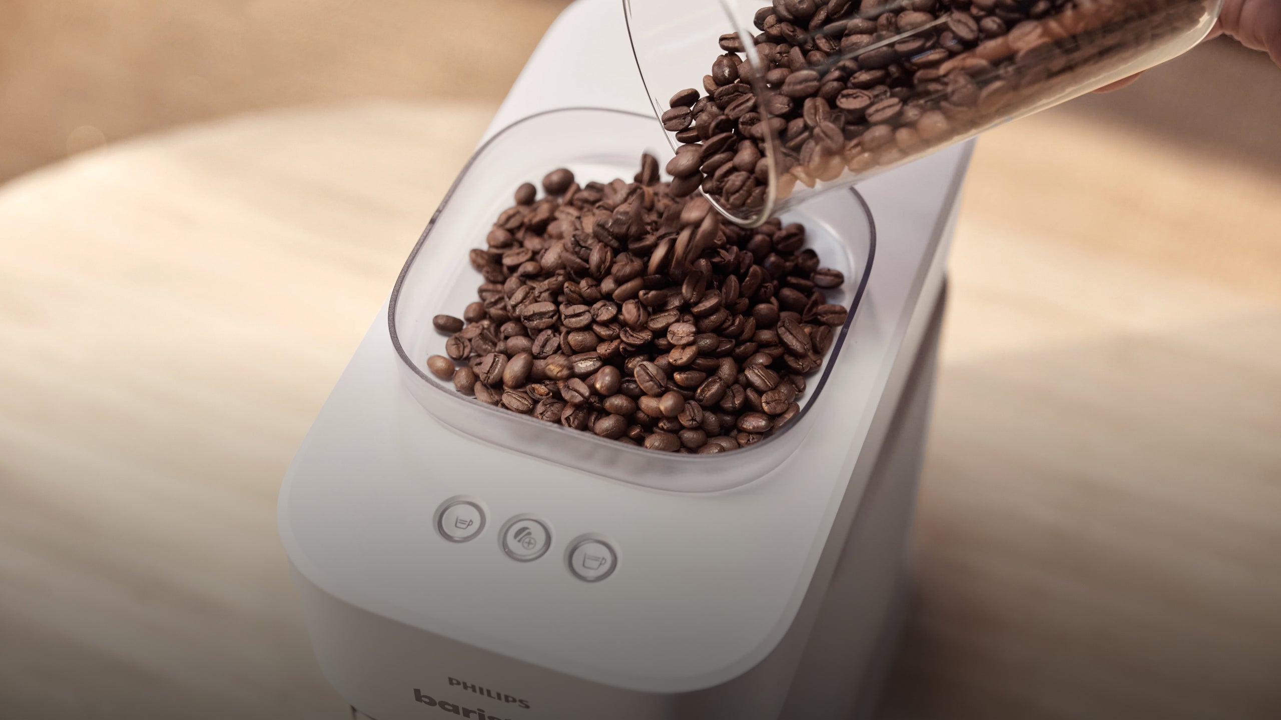Coffee beans being poured into a Philips Barista coffee machine.