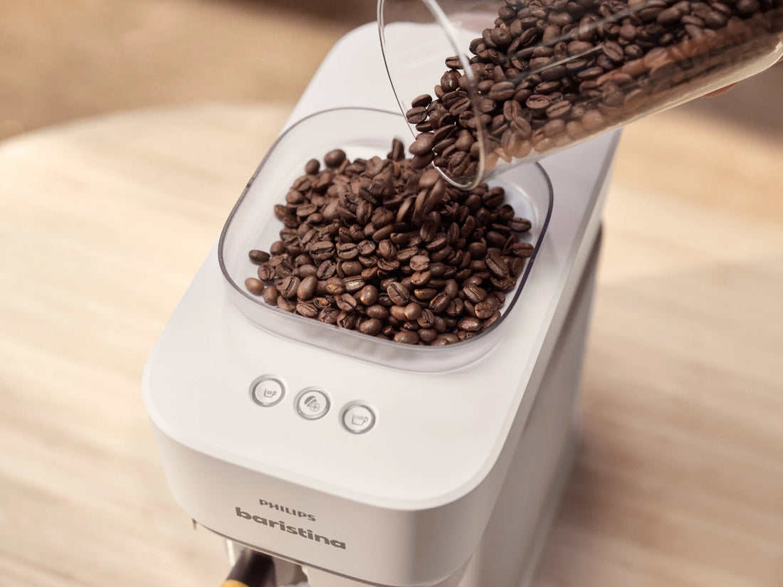 Coffee beans being poured into a Philips Barista coffee machine.