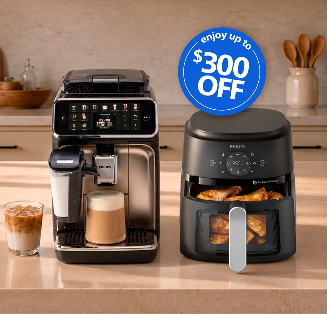 A Philips coffee machine and a Philips air fryer displayed side by side on a kitchen countertop, with a glass of iced coffee and a blue promotional badge reading '$300 OFF'.