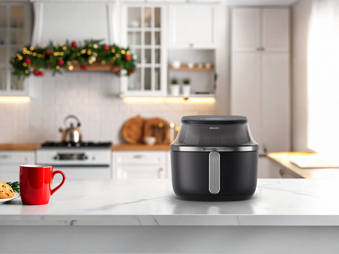 Black air fryer on a kitchen counter with a festive background