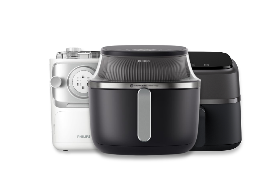 Two Philips air fryers and Philips Pasta Maker shown together on a white background: a white model at left, a central black model in front, and a dark gray model at right.