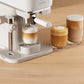 Espresso machine with two glasses of coffee on a wooden surface
