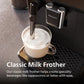 Philips milk frother in action with a cup of frothed milk on a coffee machine.