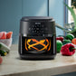 Philips air fryer on a kitchen counter with vegetables in the background