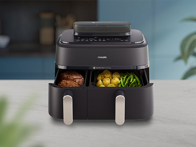 Philips airfryer with steam with food items on a kitchen counter