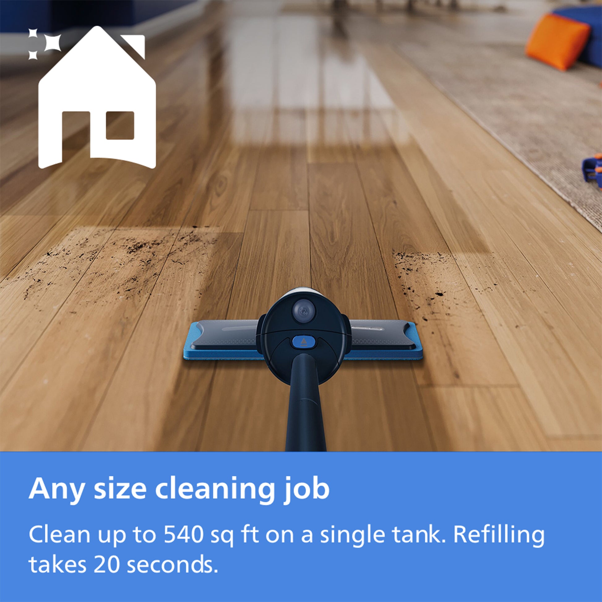 A cordless floor cleaner head shown from above on a hardwood floor, with a white house icon in the top left and a blue text banner at the bottom reading 'Any size cleaning job Clean up to 540 sq ft on a single tank. Refilling takes 20 seconds.