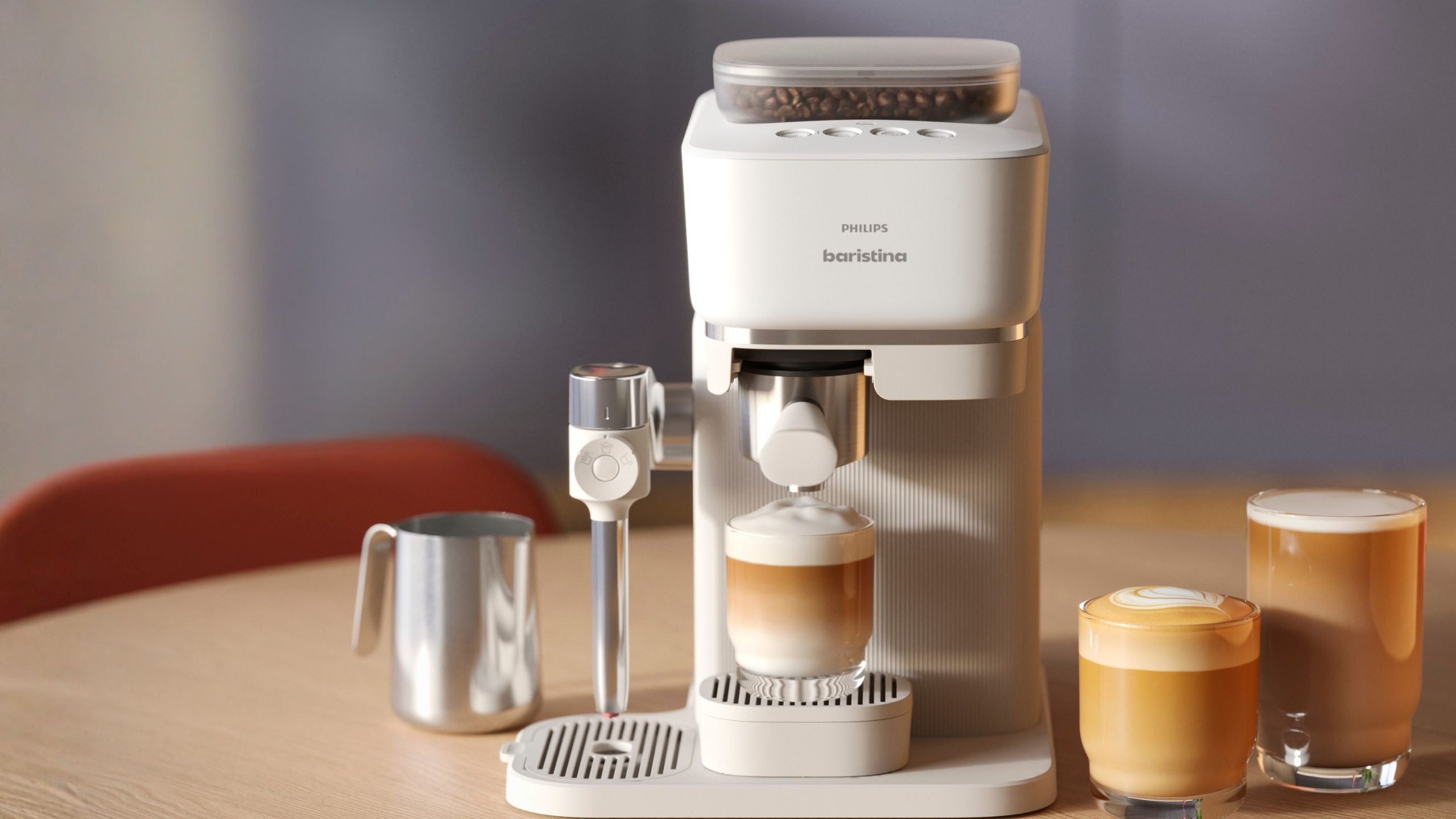 White coffee machine on a wooden table with two glasses of coffee and a milk container.