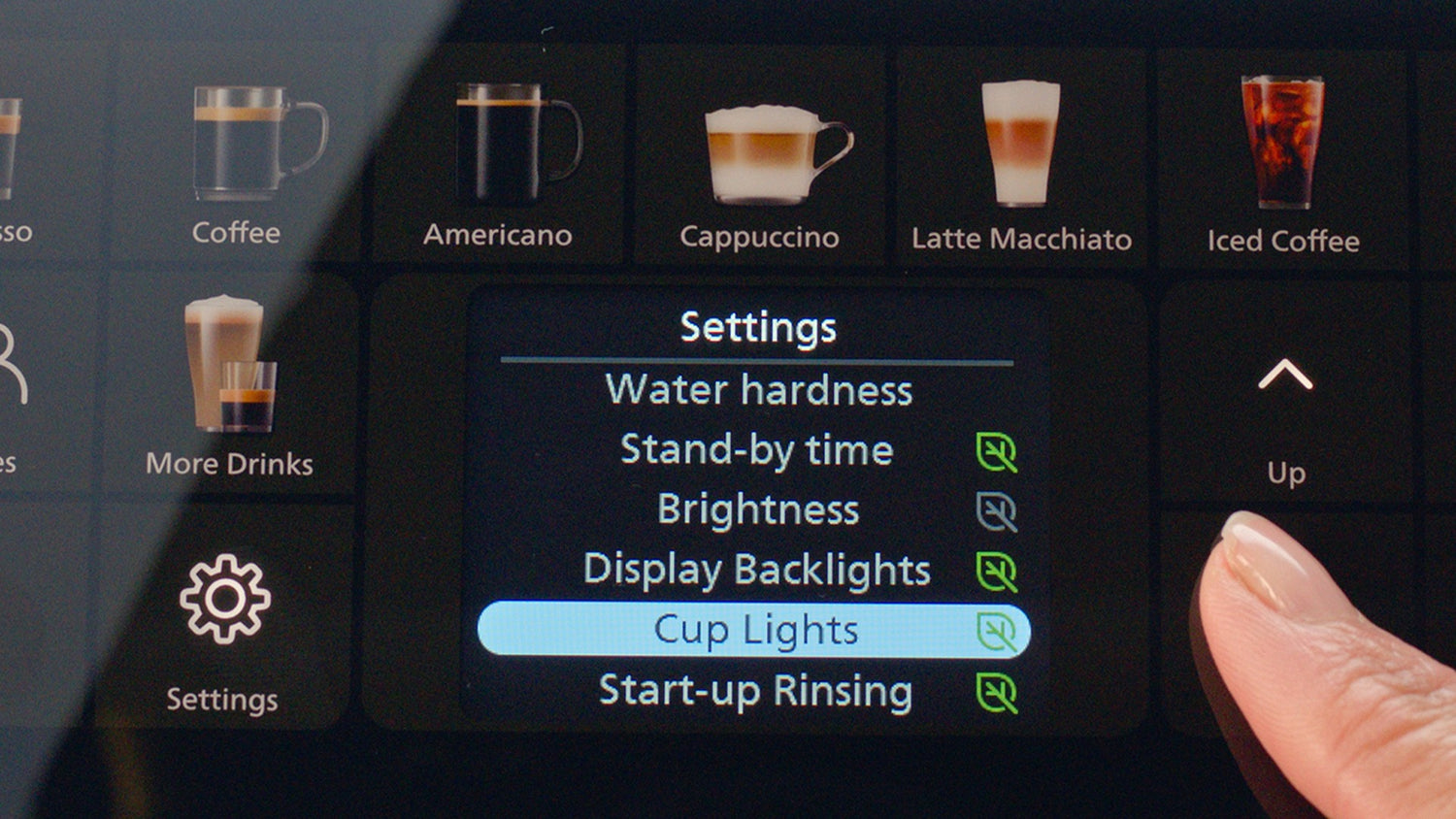 Coffee machine settings screen with various coffee options and a hand interacting with the device.